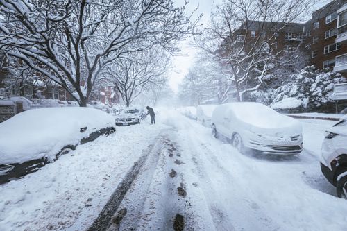 Free A snow-covered street in New York City during a winter snowstorm featuring snow removal. Stock Photo