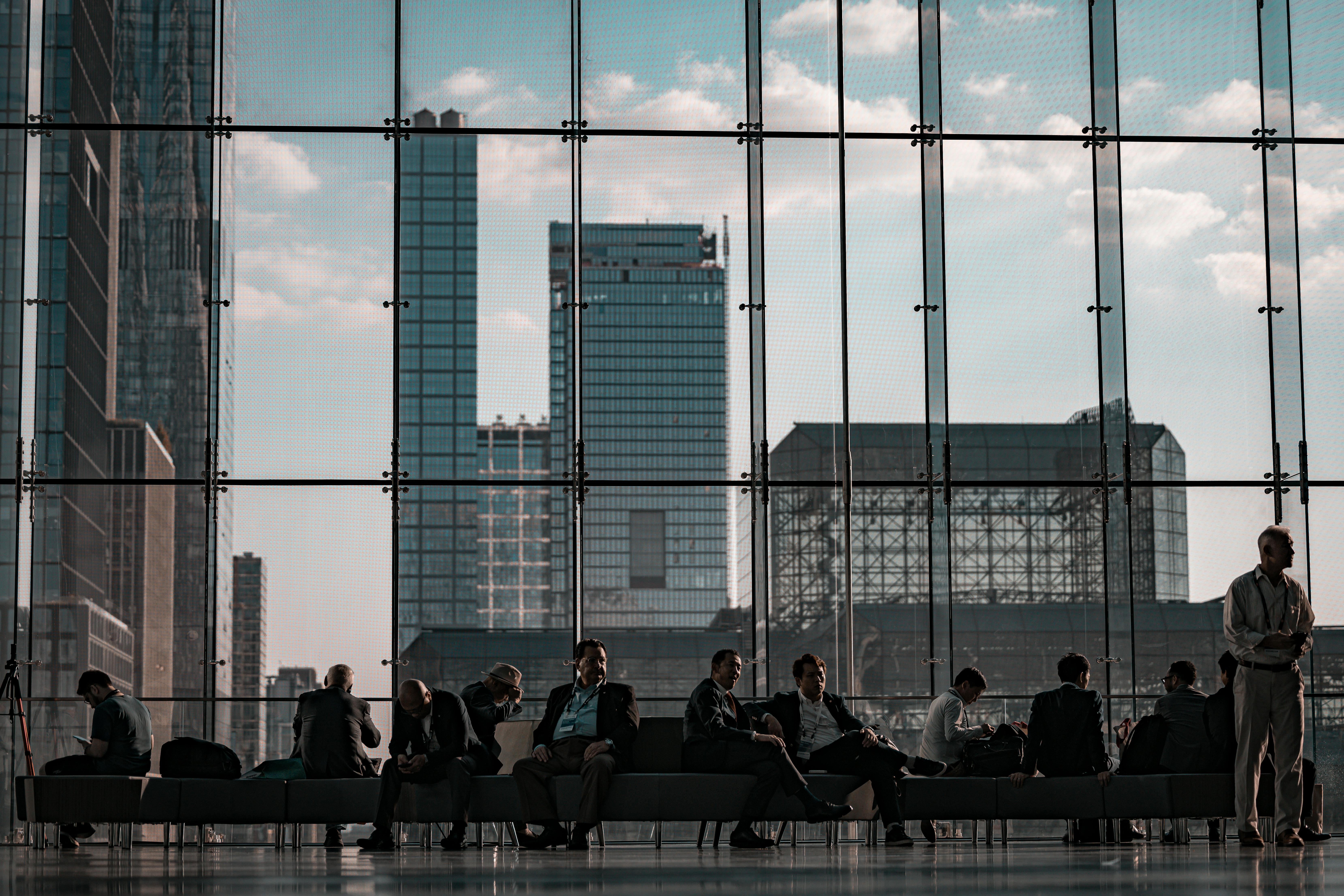 Business professionals at the Javits Center, New York City featuring urban skyline through glass facade.