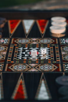Colorful backgammon board with dice, showcasing intricate geometric design and traditional game layout.