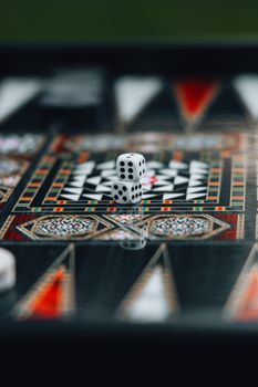 Close-up of a backgammon board with a single dice, highlighting intricate designs.