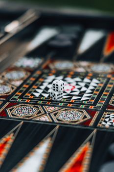 A detailed close-up of a colorful backgammon board with dice, showcasing intricate patterns and design.