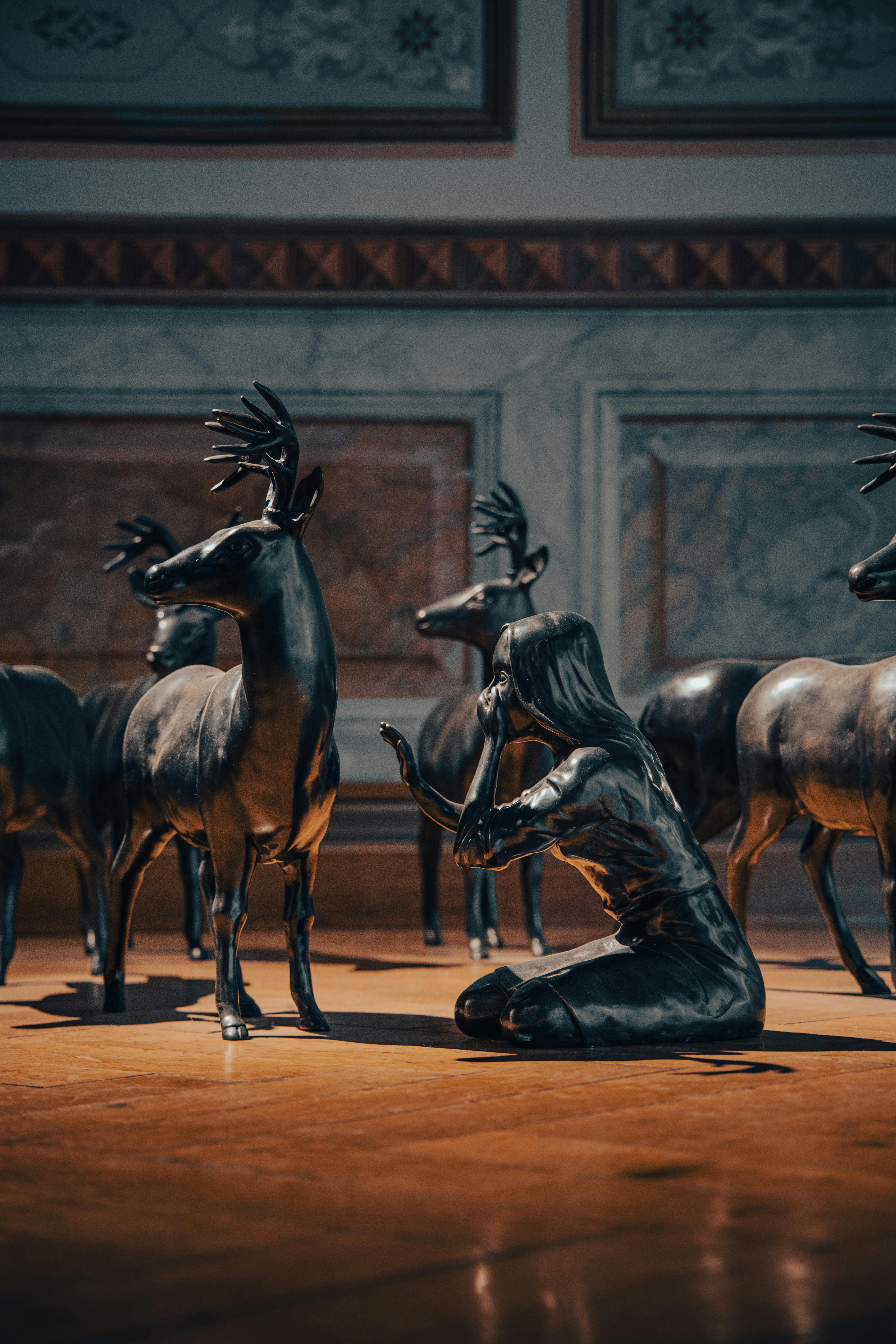 бесплатная Завораживающая бронзовая скульптура женщины с оленями в элегантной художественной галерее. Стоковое фото