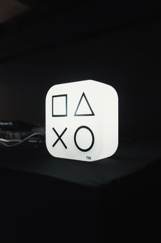 Modern minimalist lamp featuring iconic gaming symbols, glowing in dark setting.