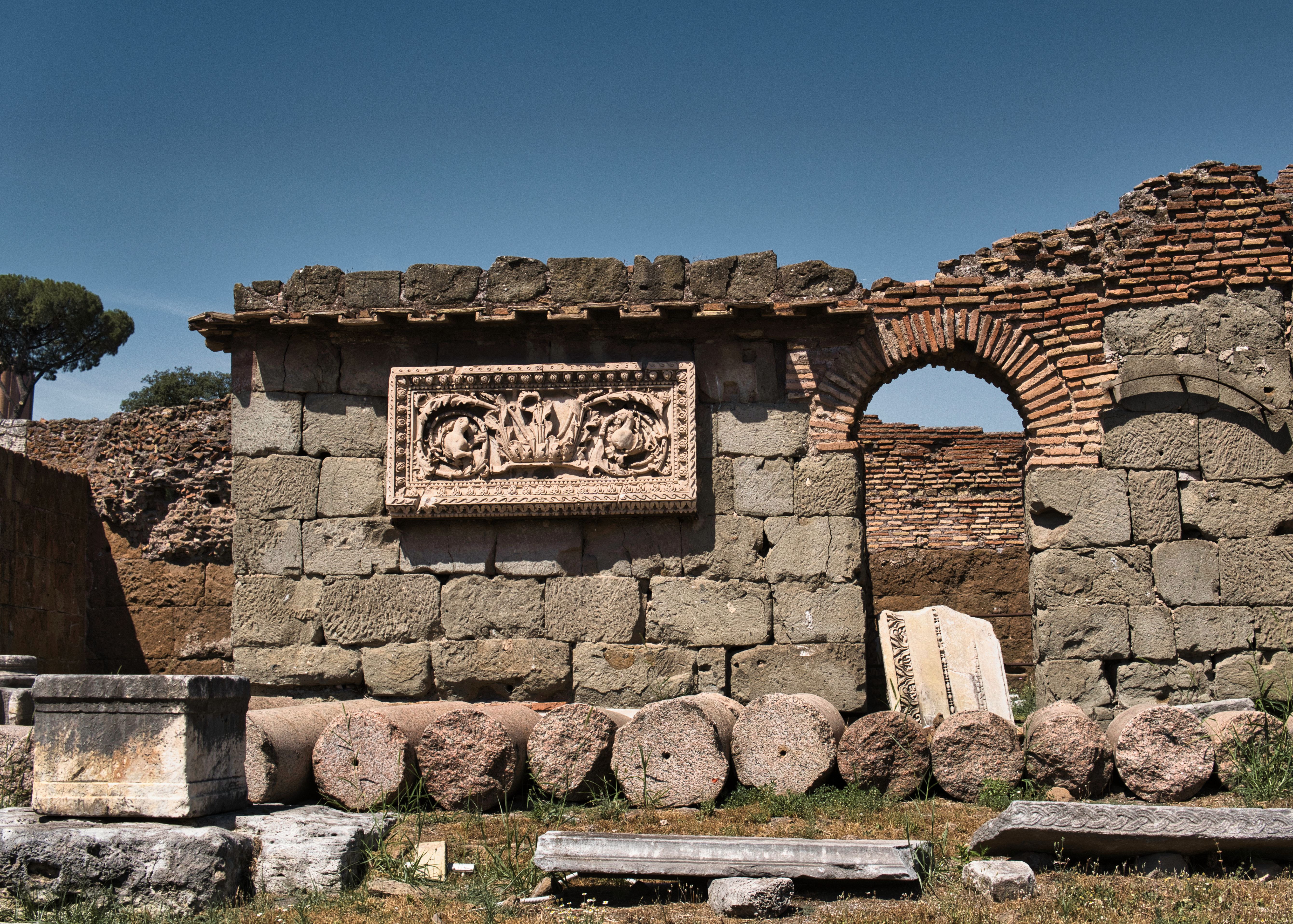Explore the historic ruins of ancient Rome with stone arches and carvings.