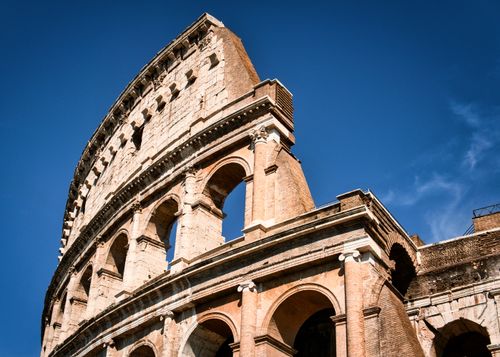 Free View of the iconic Colosseum in Rome, Italy, under a clear blue sky. Stock Photo