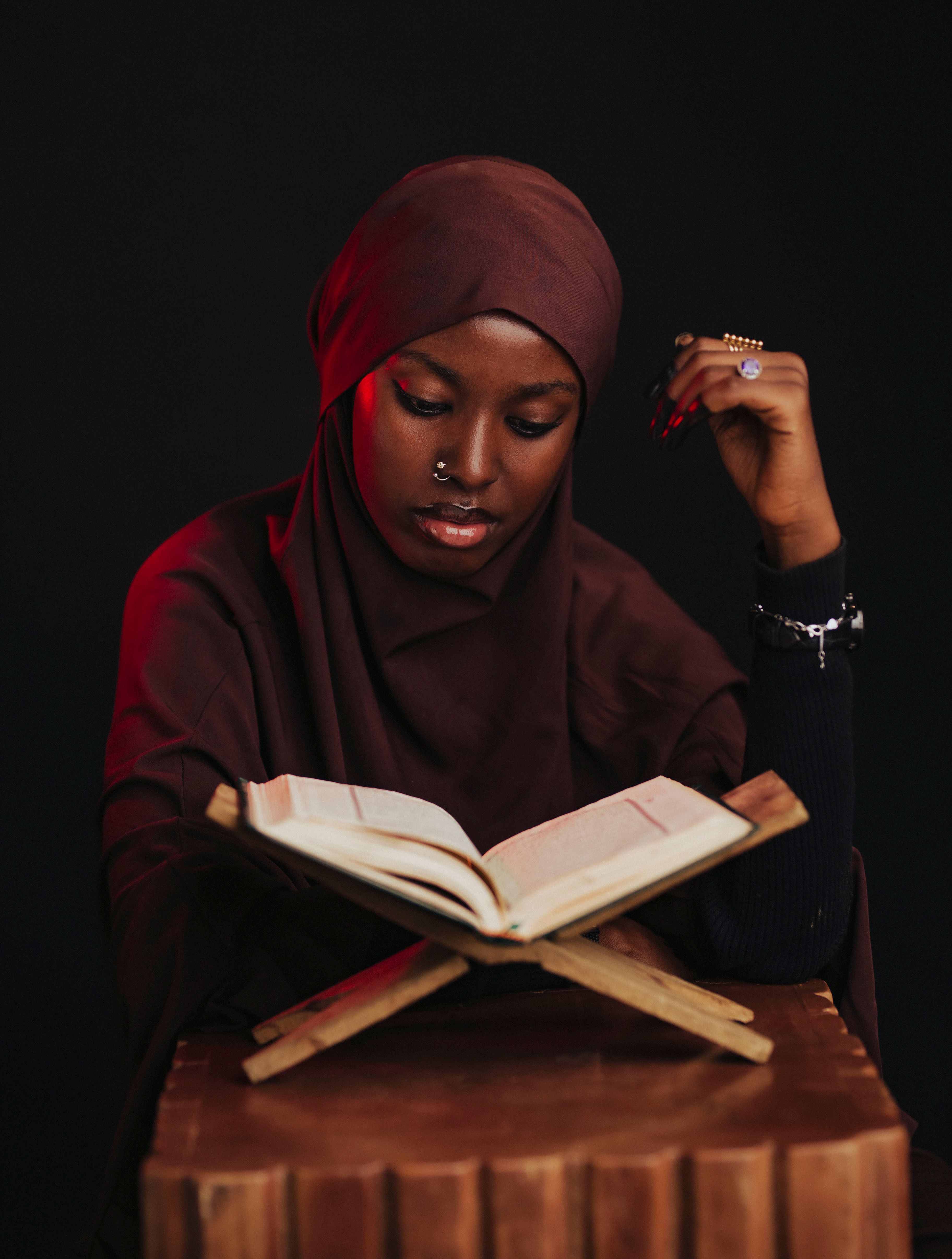 Contemplative Woman in Hijab Reading a Book · Free Stock Photo
