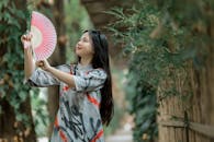 Young Woman Enjoying Nature with Pink Fan