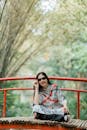 Woman Relaxing on a Vibrant Red Bridge Outdoors