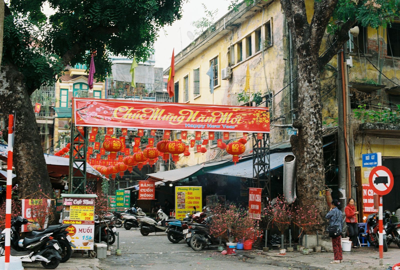 Lunar New Year celebration street scene in Vietnam with red decorations and motorbikes