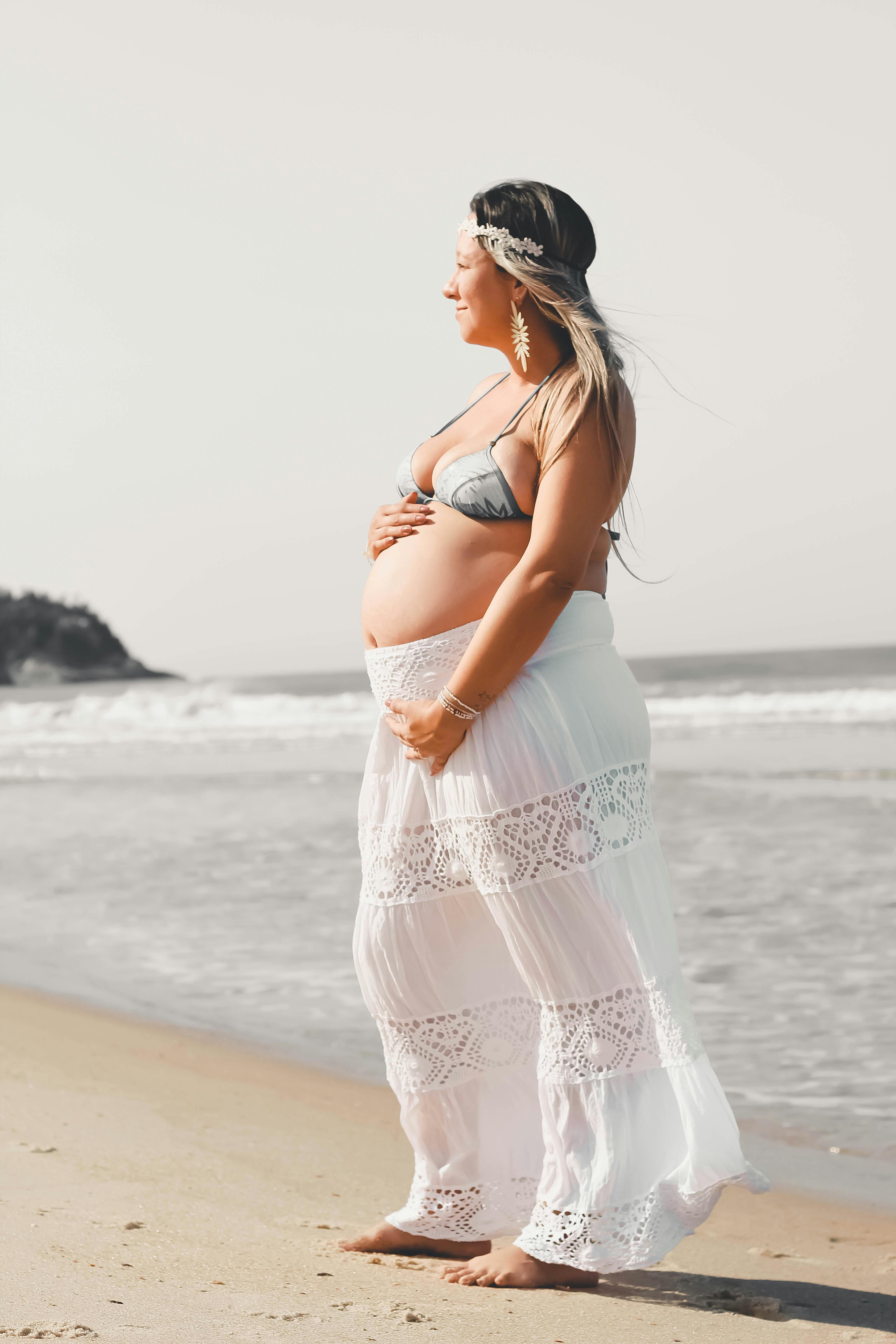 woman in white and pink floral dress standing on beach