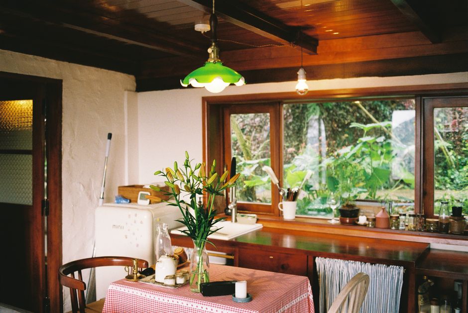 Photo by Dương Nhân on Pexels Bright rustic kitchen with floral centerpiece and natural lighting, creating a cozy and inviting atmosphere.