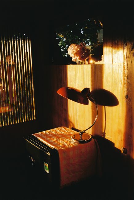A dimly lit room with a vintage lamp casting warm shadows indoors.