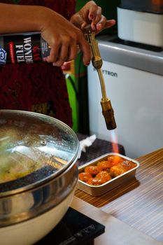 Chef using a blowtorch to caramelize food in a modern kitchen. Culinary precision at its best.