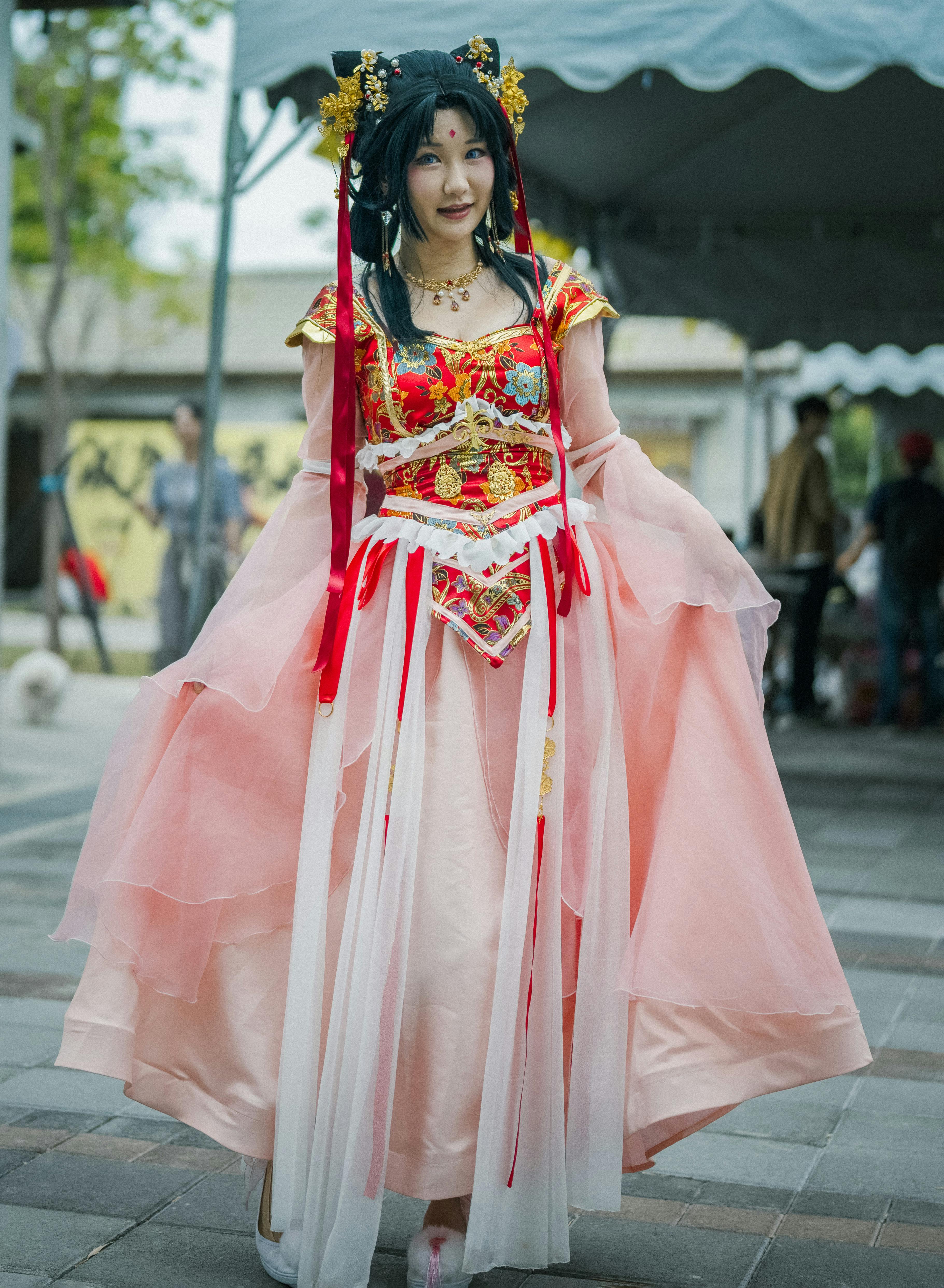 Gratis Seorang wanita mengenakan pakaian tradisional Asia yang rumit di sebuah festival budaya luar ruangan. Foto Stok