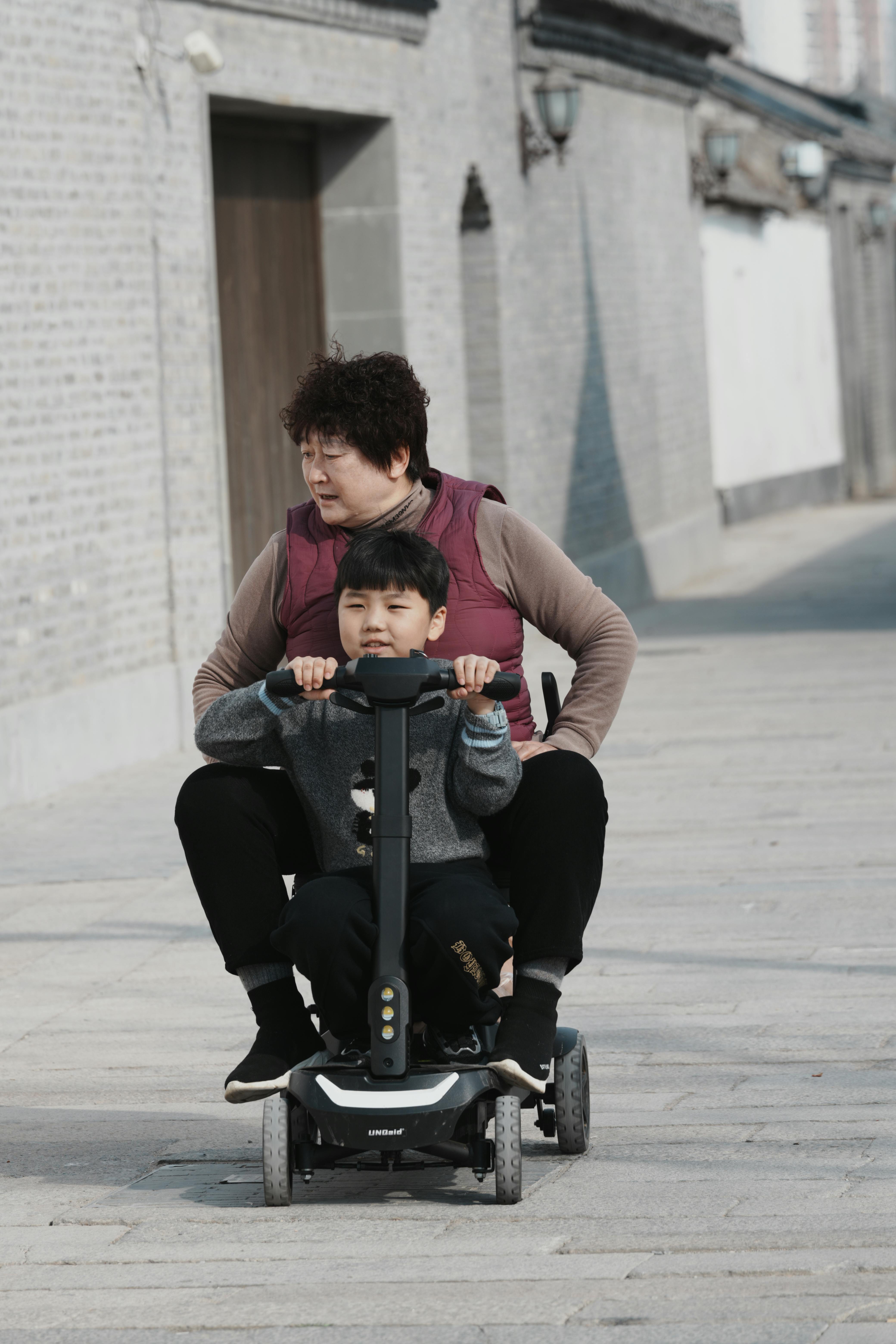 免費 一位老婦人和一位小男孩在戶外享受騎滑板車的樂趣。 圖庫相片