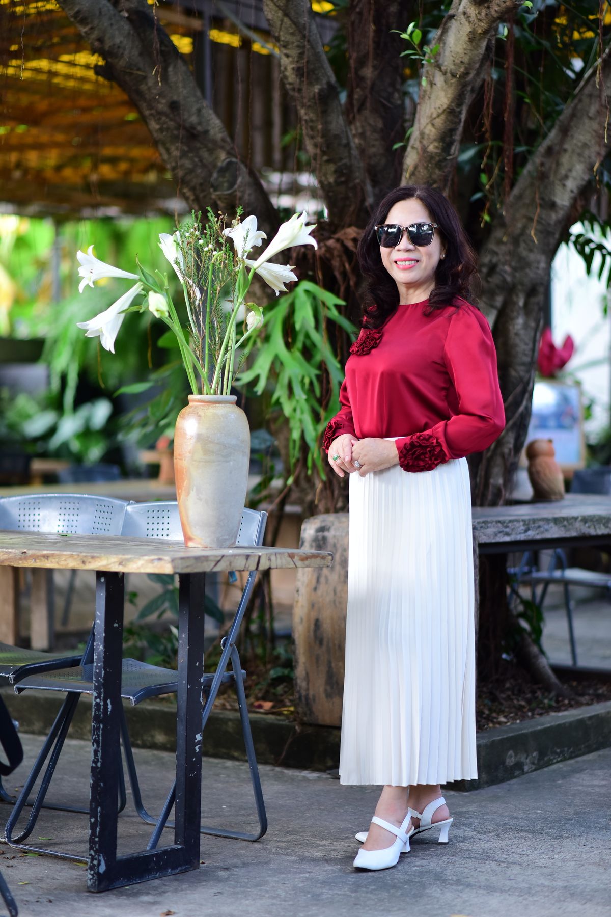 Burgundy Outfits for Women — 7 Wine Red Looks for Fall and Winter Woman in a burgundy top and cream skirt posing outdoors