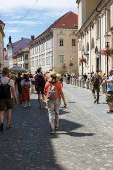 A lively European street scene with tourists exploring historic architecture.