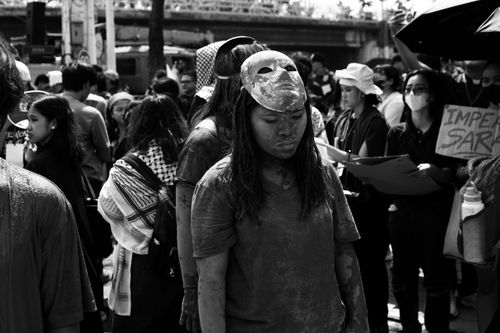 Free Black and white photo of a protest with a masked participant, highlighting civil unrest. Stock Photo
