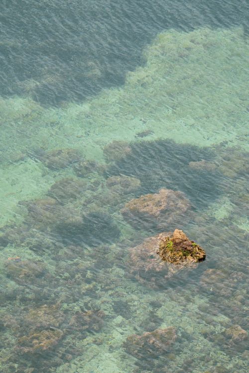 Free Aerial view of a rocky seascape in Provence-Alpes-Côte d'Azur, France, with clear blue water. Stock Photo