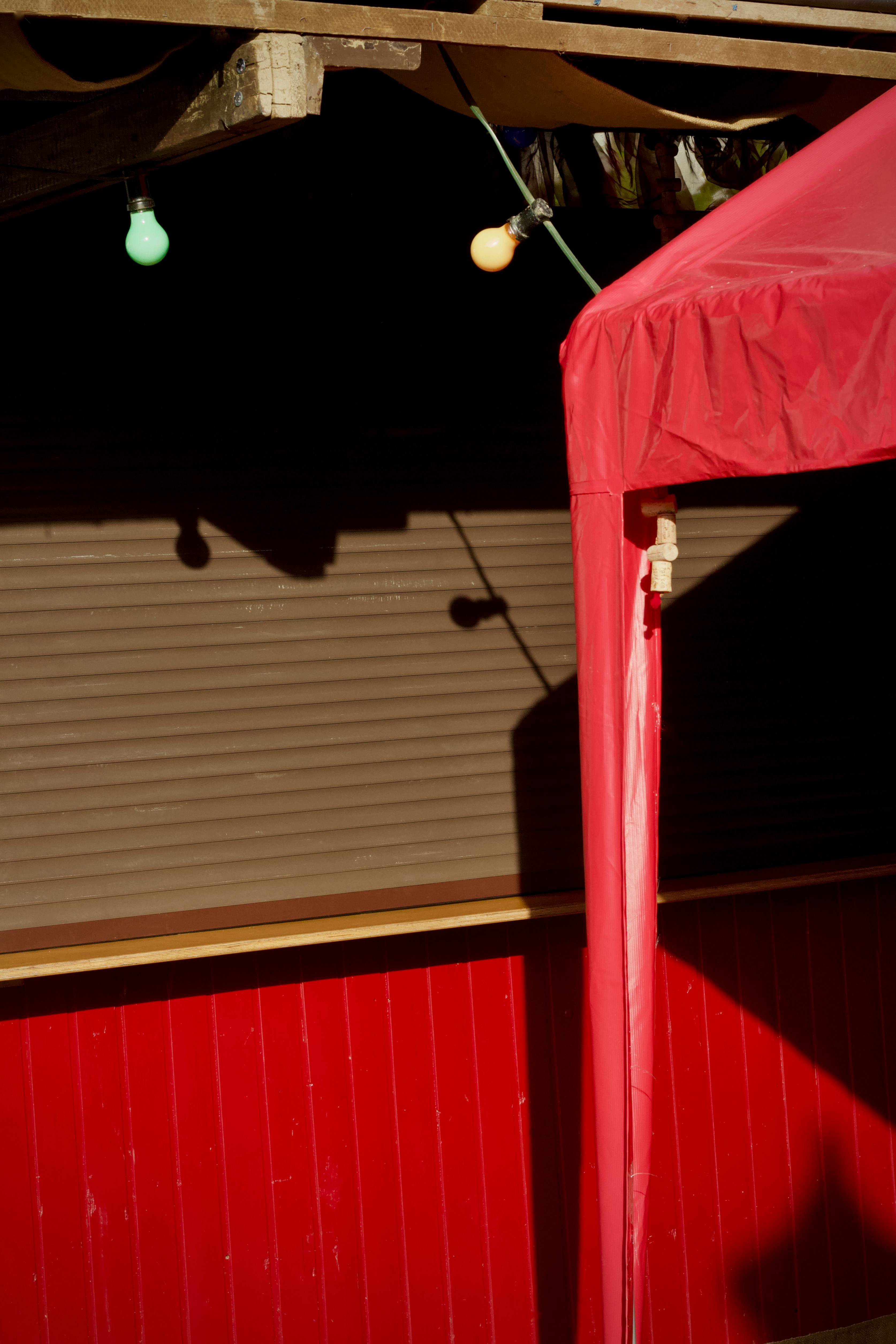 Free Vibrant street market scene showcasing a red canopy and hanging lights. Stock Photo