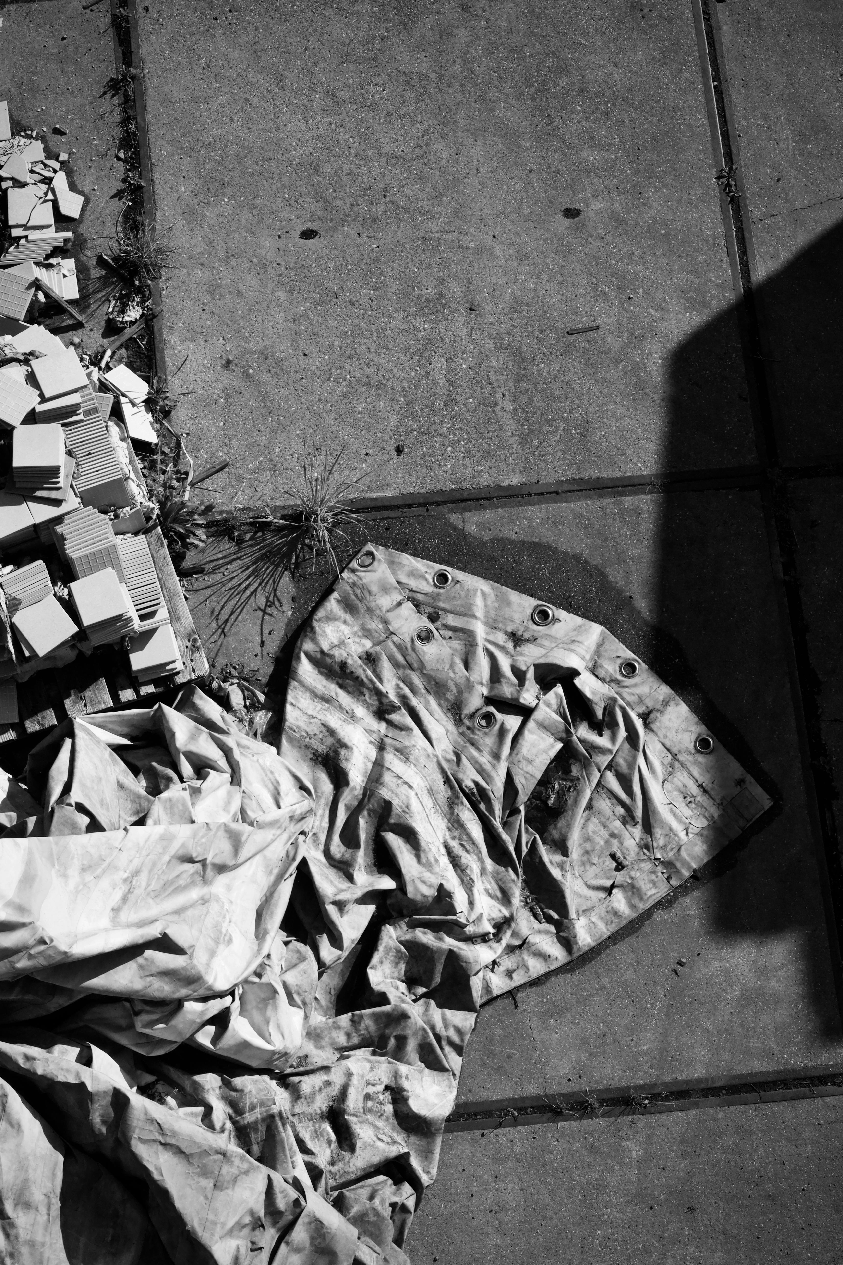 Gratis Foto monocromatica di un telo e detriti edili su cemento. Foto a disposizione