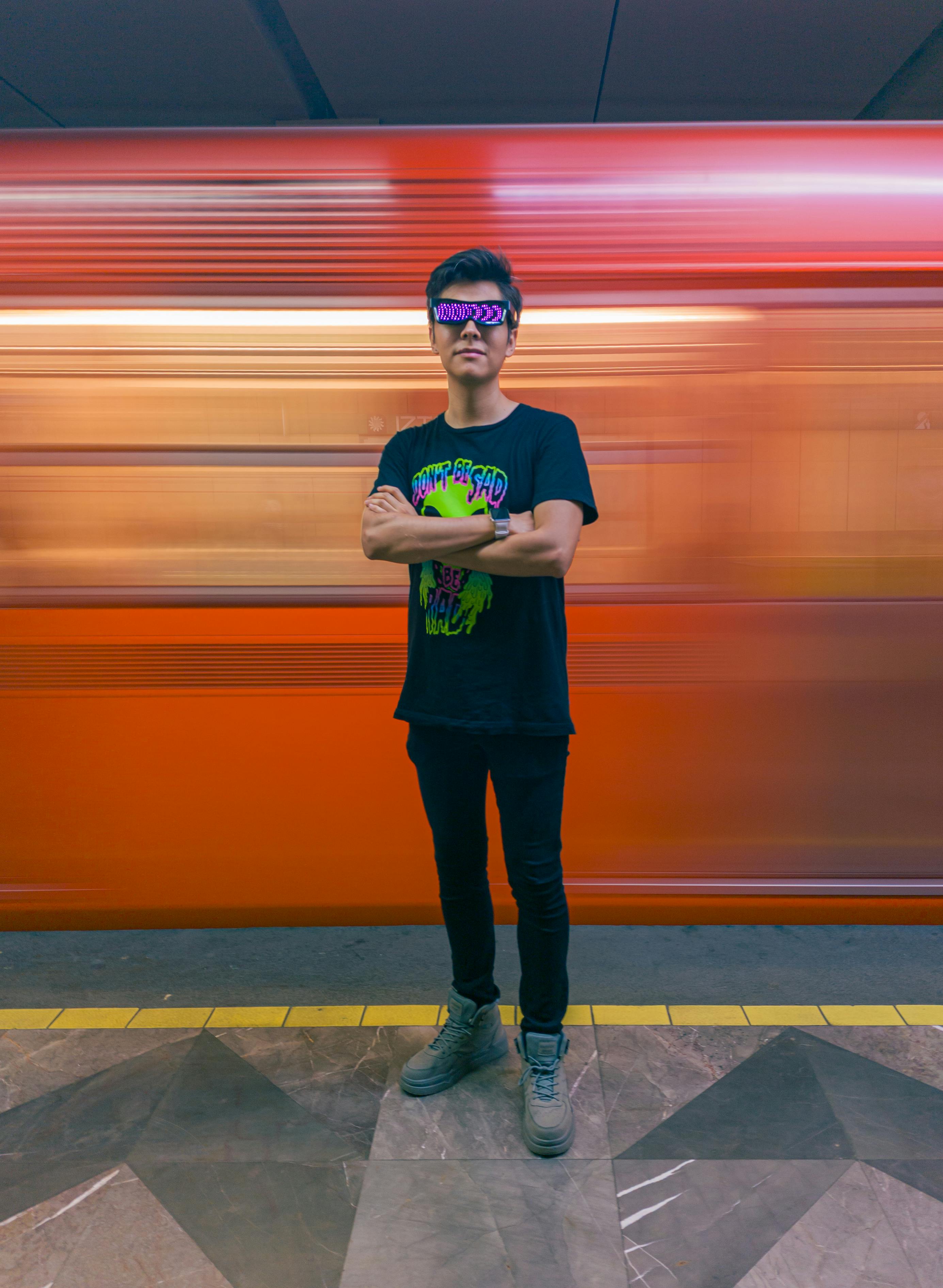 Free Person with blindfold and graphic tee in front of moving metro train in Mexico City subway. Stock Photo