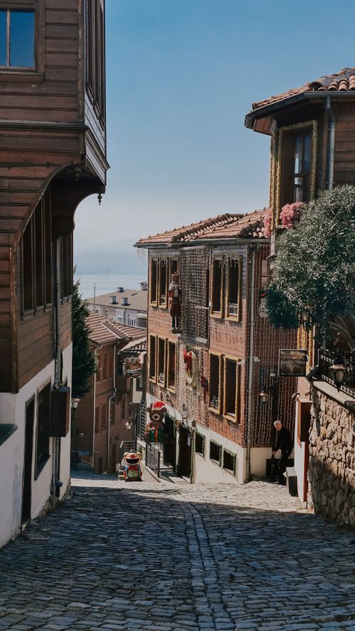 Free Picturesque view of a cobblestone street lined with traditional wooden houses on a sunny day. Stock Photo