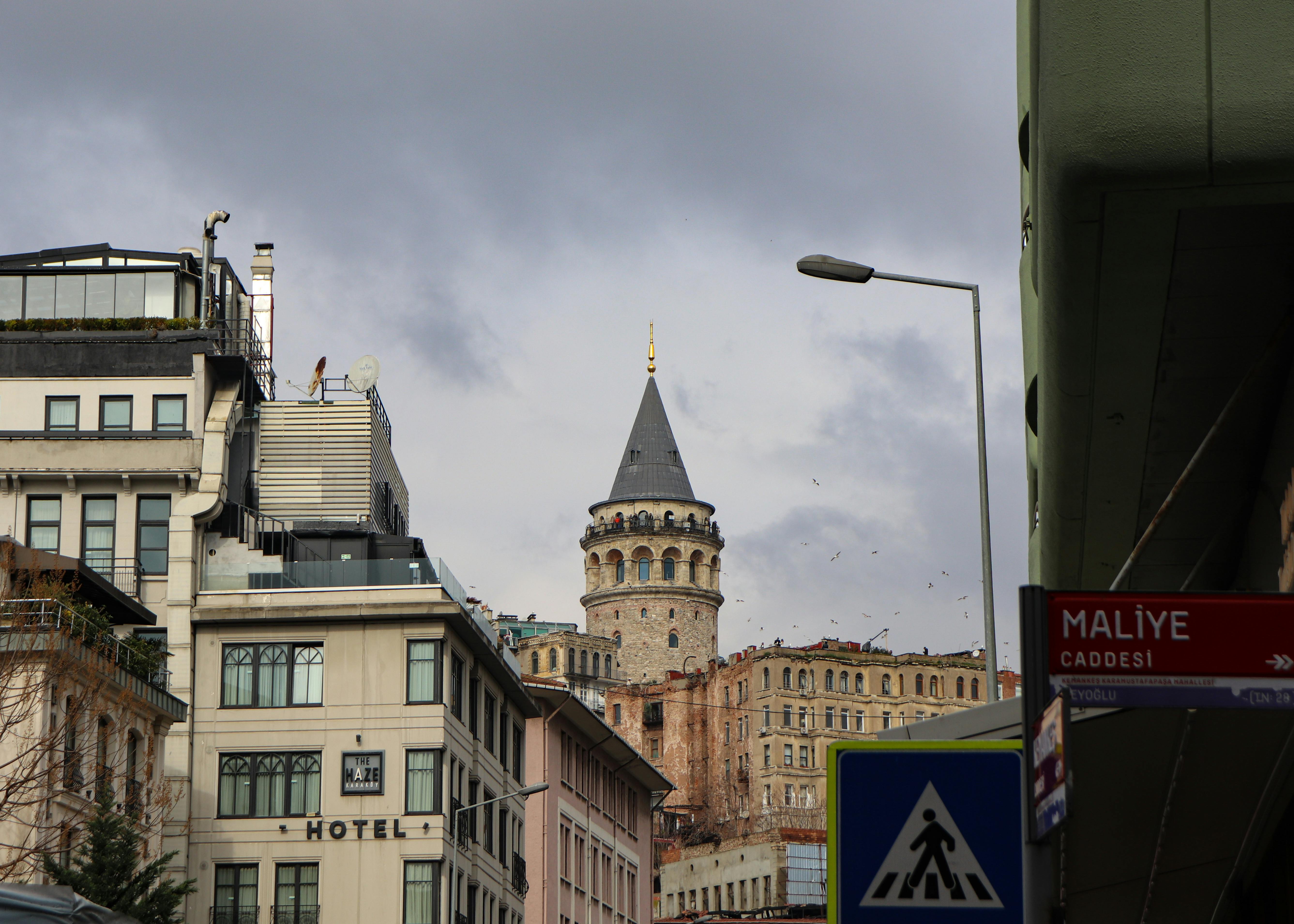 Free Scenic urban view featuring the iconic Galata Tower in Istanbul, under a cloudy sky. Stock Photo