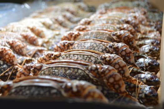 A close-up of fresh blue crabs arranged neatly at a seafood market, showcasing their texture.