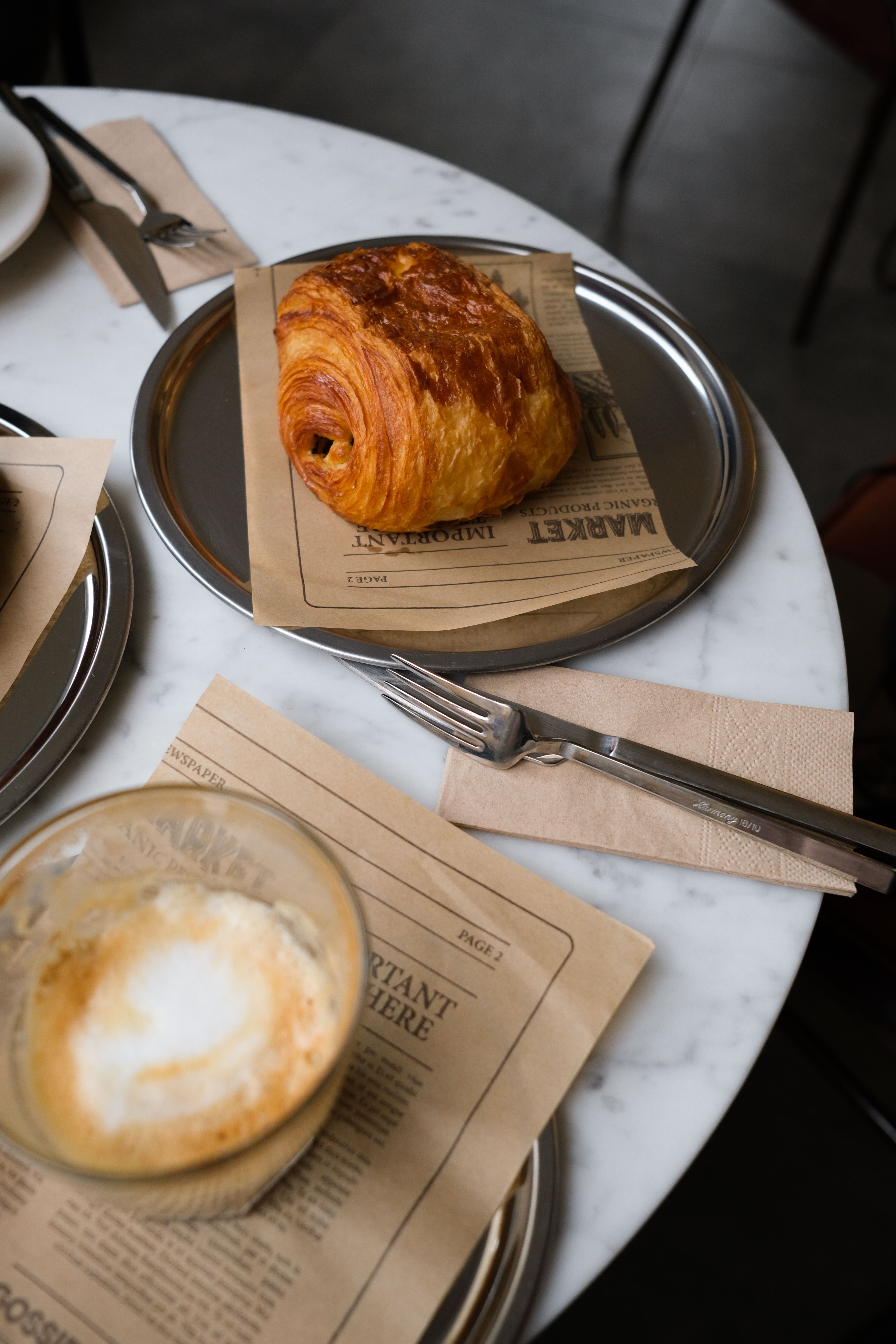 Pain au chocolat and a cappuccino on the window seat table