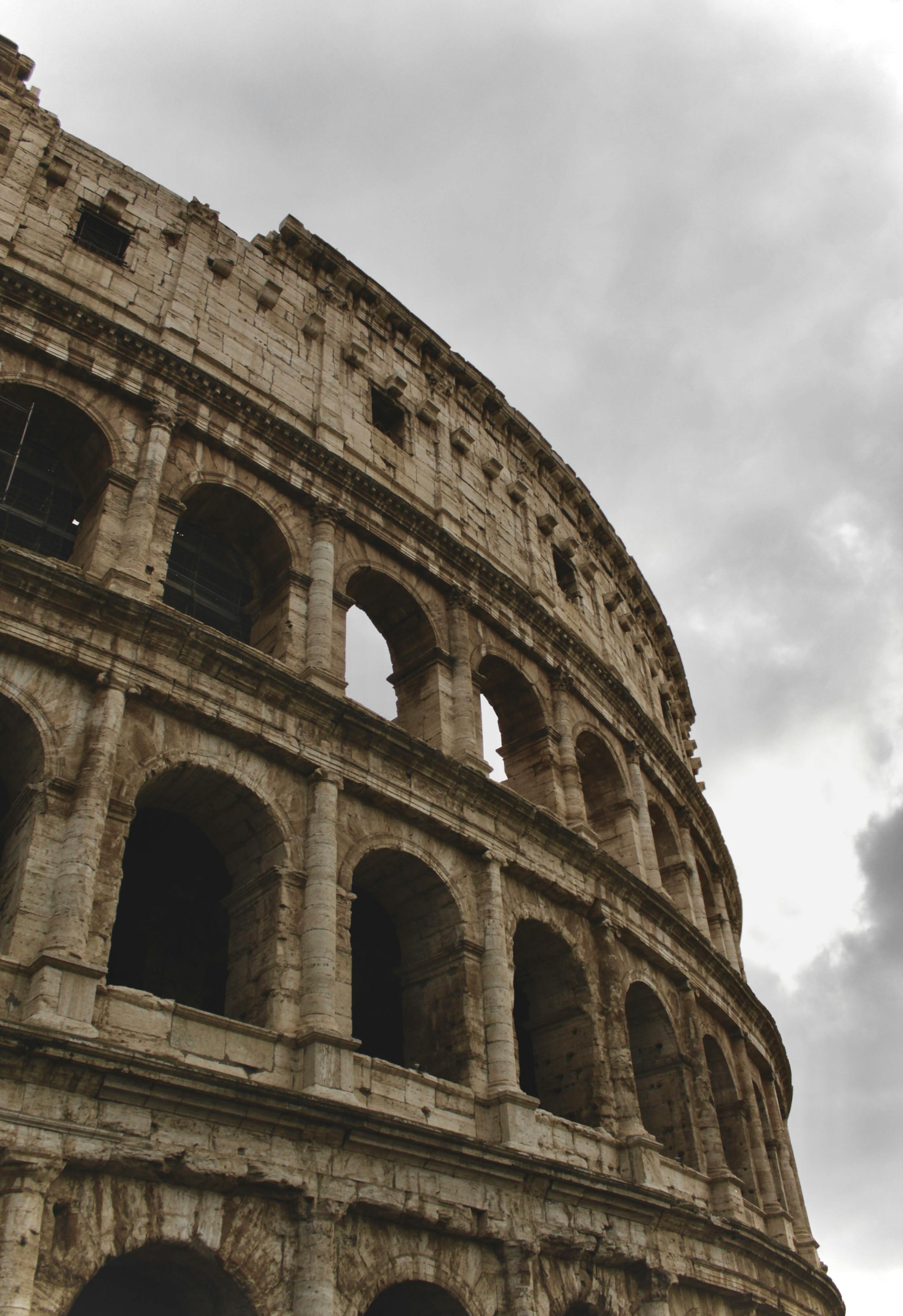 無料 憂鬱な曇り空の下で撮影された、イタリア、ローマのコロッセオの象徴的な景色。 写真素材