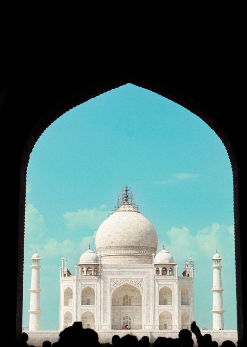 Free Stunning view of the Taj Mahal framed by a grand archway, emphasizing its iconic beauty and architecture. Stock Photo