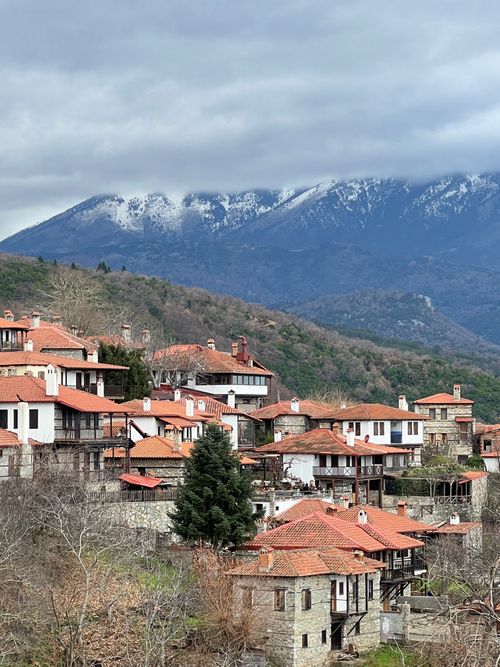 Free A picturesque village with red roofs against snow-capped mountains, set in winter. Stock Photo