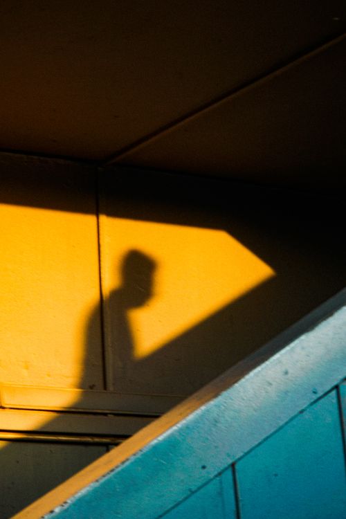Free Dramatic silhouette of a person on stairs with colorful geometric lighting. Stock Photo