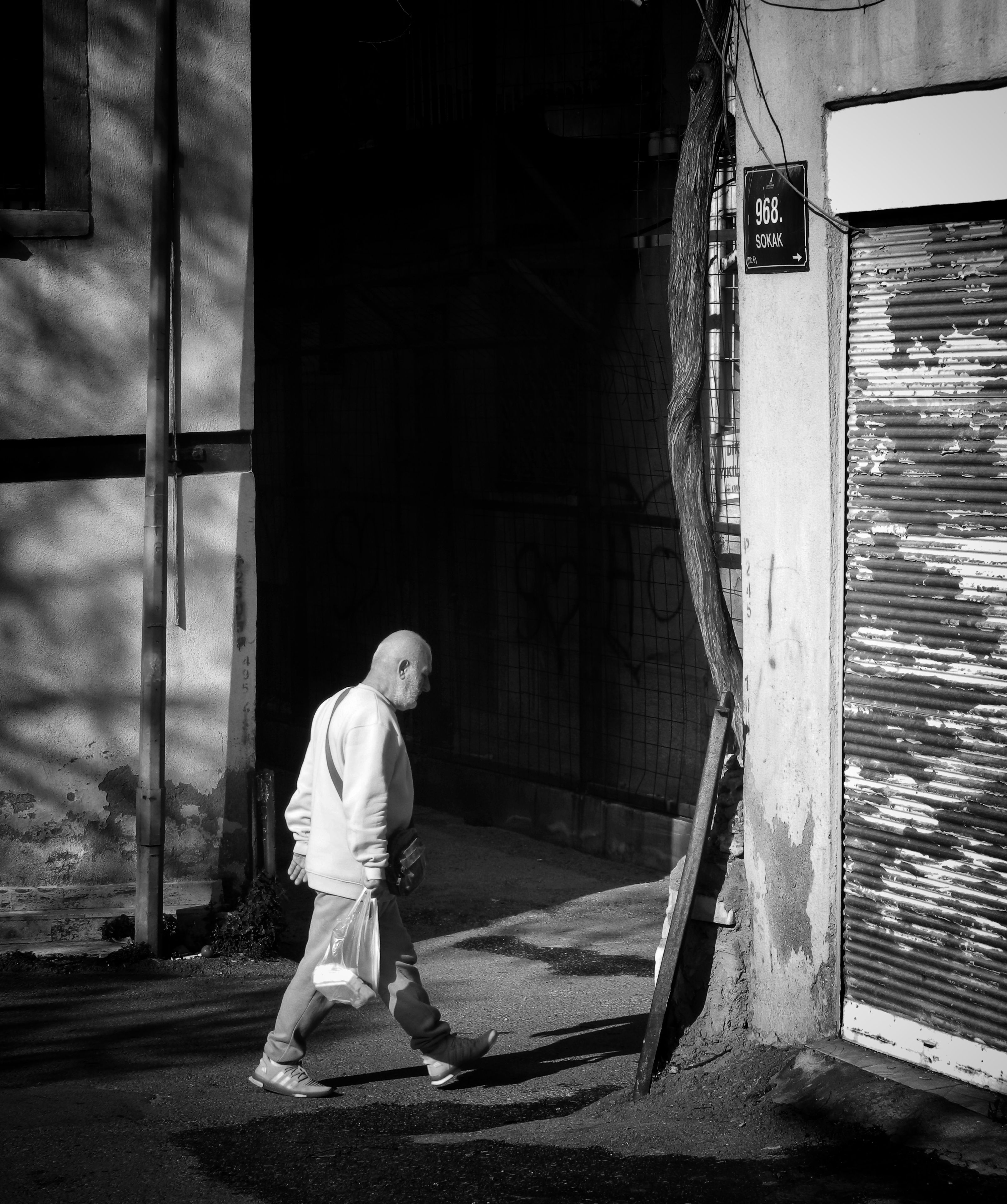 Elderly Man Walking Past Urban Building in Black and White · Free Stock ...