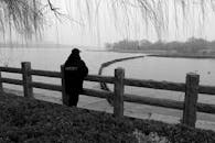 Lonely Figure Overlooking Calm Lake in Winter