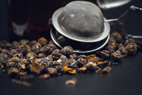 fresh brown coffee beans in metal strainer