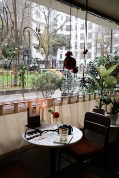 Inviting cafe interior with a charming window view, perfect for a cozy afternoon or atmospheric reading session.