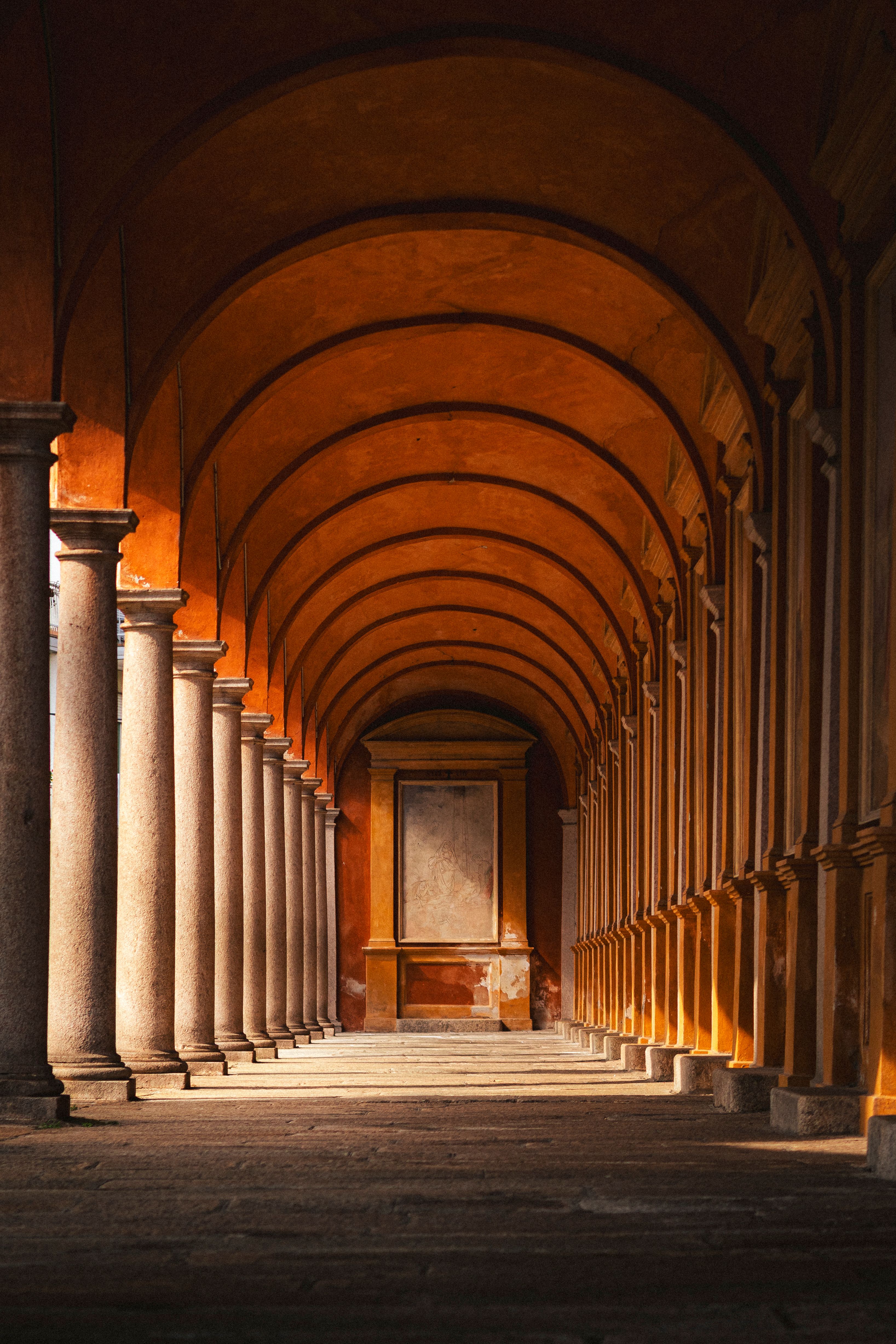 A stunning view of a warm-lit arched corridor with historical architectural symmetry.