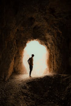 A person stands silhouetted against bright light at the entrance of a cave in Erzincan, Turkey.