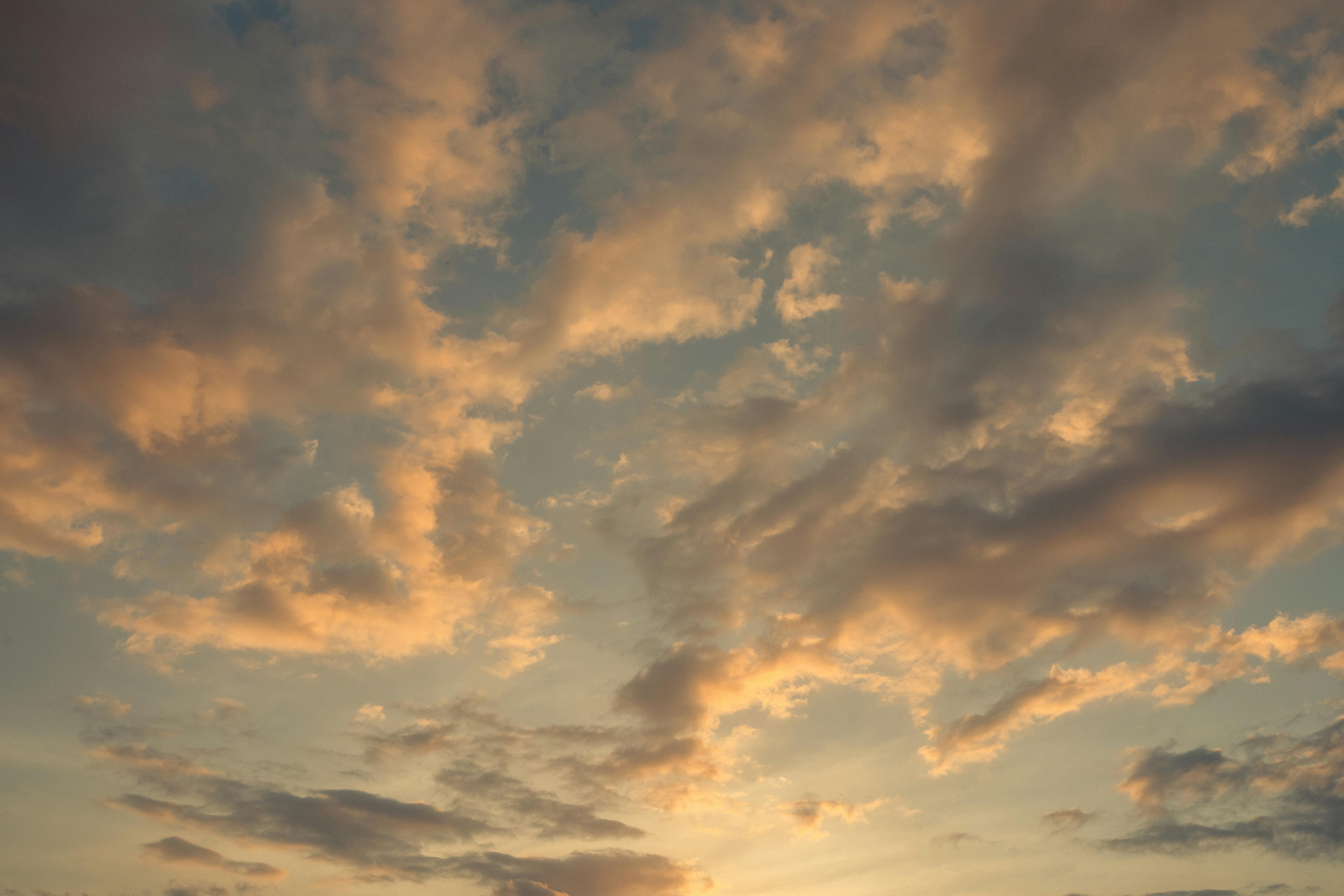 Kostenlos Sanfte Pastelltöne erfüllen den Himmel während eines friedvollen Sonnenaufgangs mit dramatischen Wolkenformationen. Stock-Foto