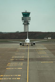 Airplane on runway aligned with control tower at Zaventem Airport, Belgium.