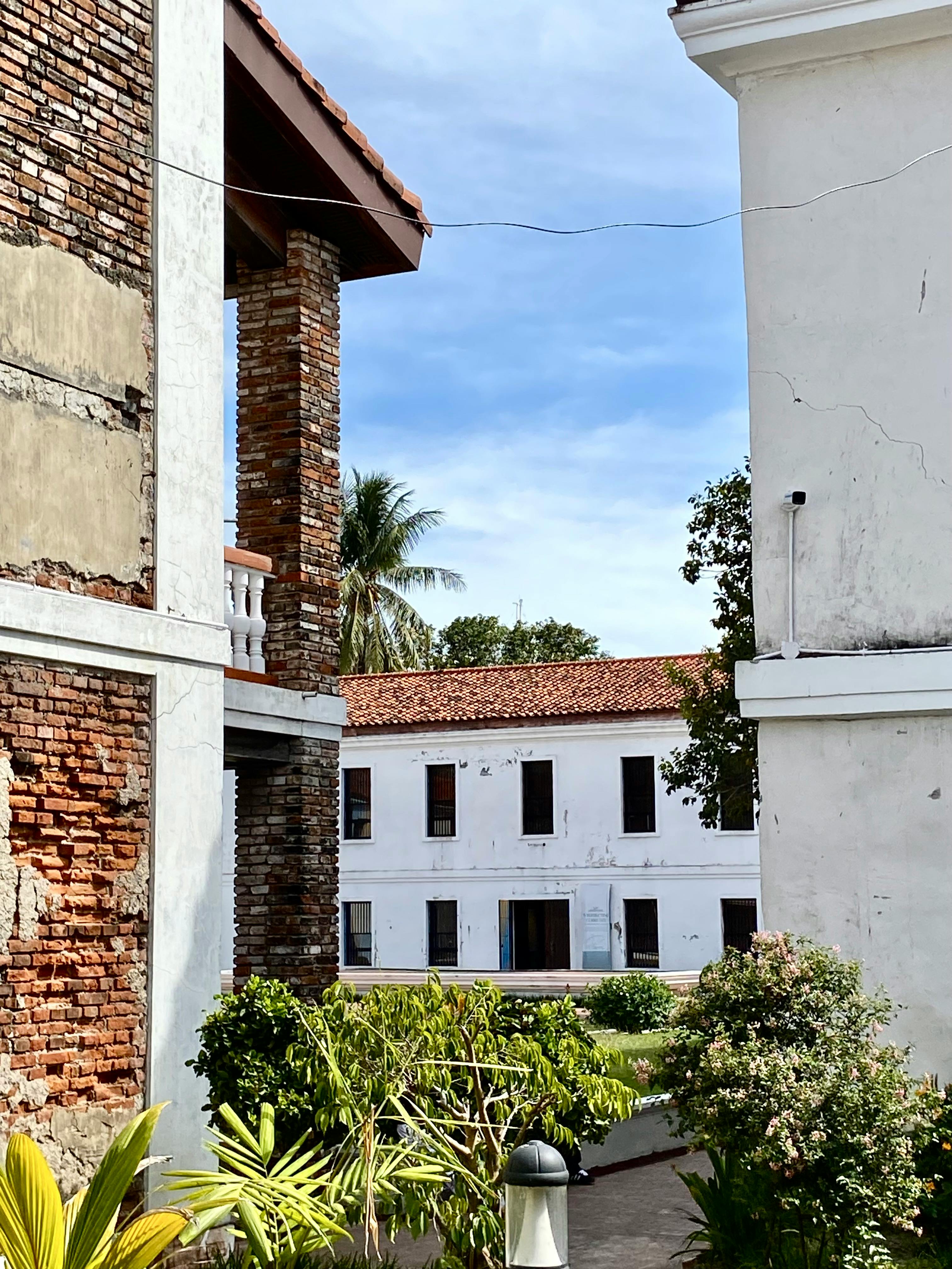 бесплатная Вид на исторические здания из красного кирпича с белыми стенами в городе Замбоанга, Филиппины. Стоковое фото