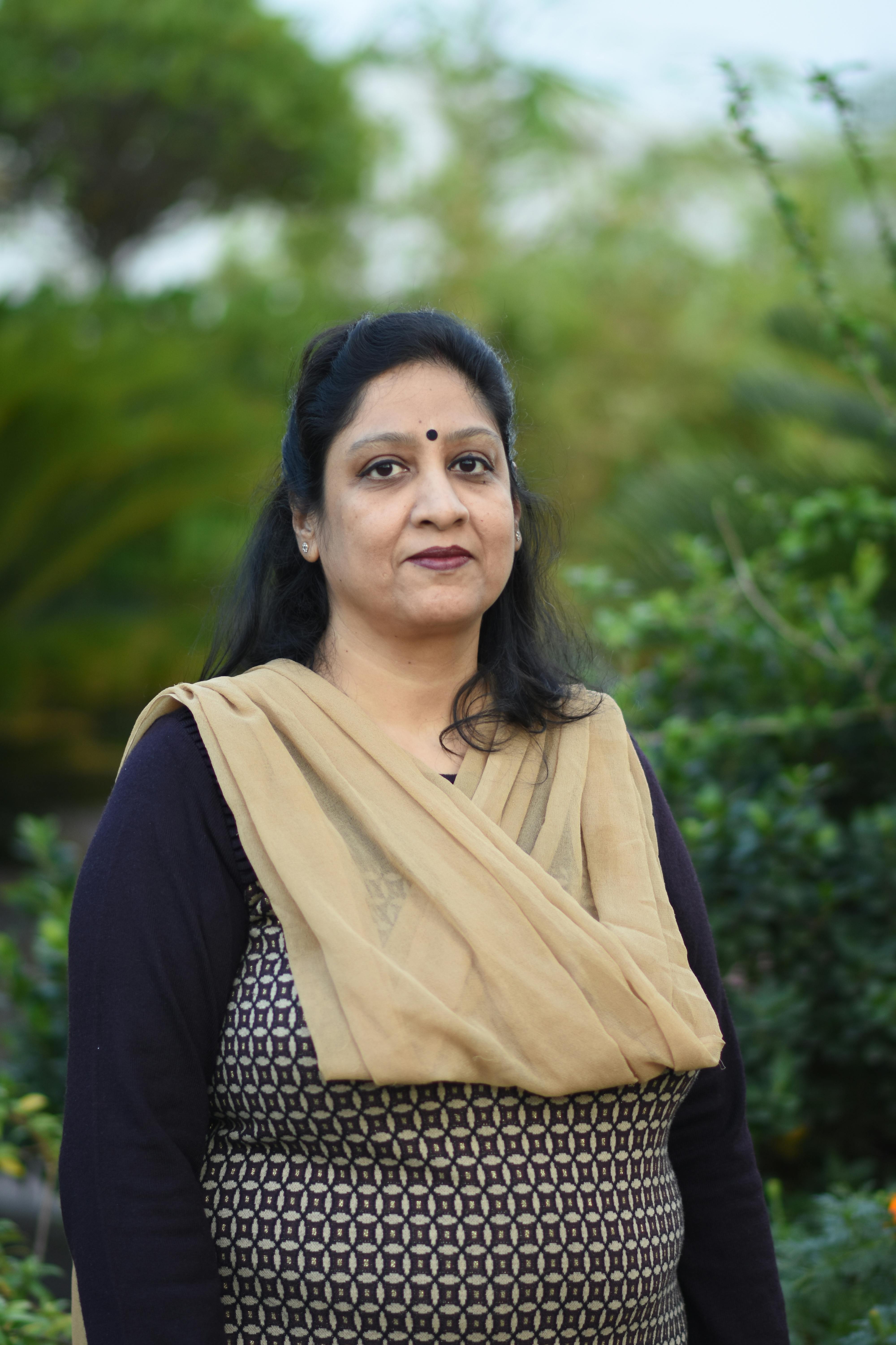 Portrait of an Indian woman wearing traditional attire in a lush garden setting, Puri, India.