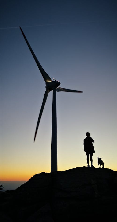 Silhouette Of Person Standing Near Windmill