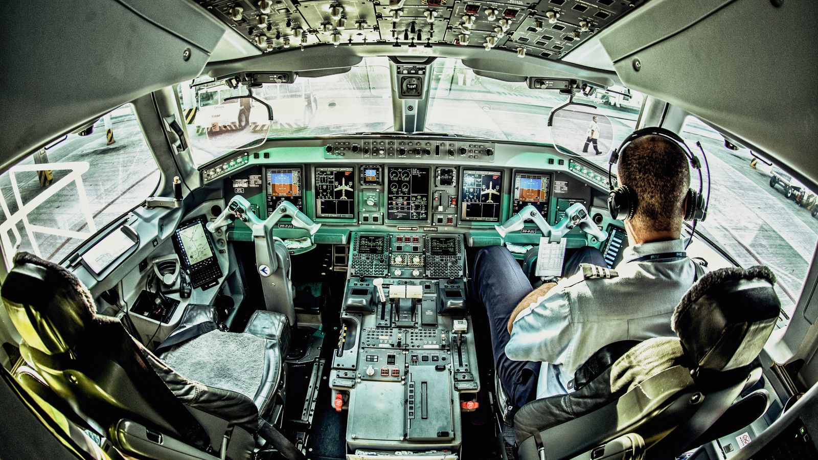 View of an airplane cockpit with a pilot actively managing the controls.