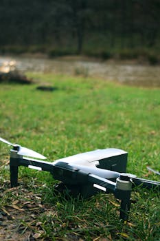 A close-up shot of a drone resting on green grass beside a river in Istanbul, Türkiye.