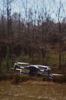 Aerial drone flying over a tranquil lake surrounded by a forest.