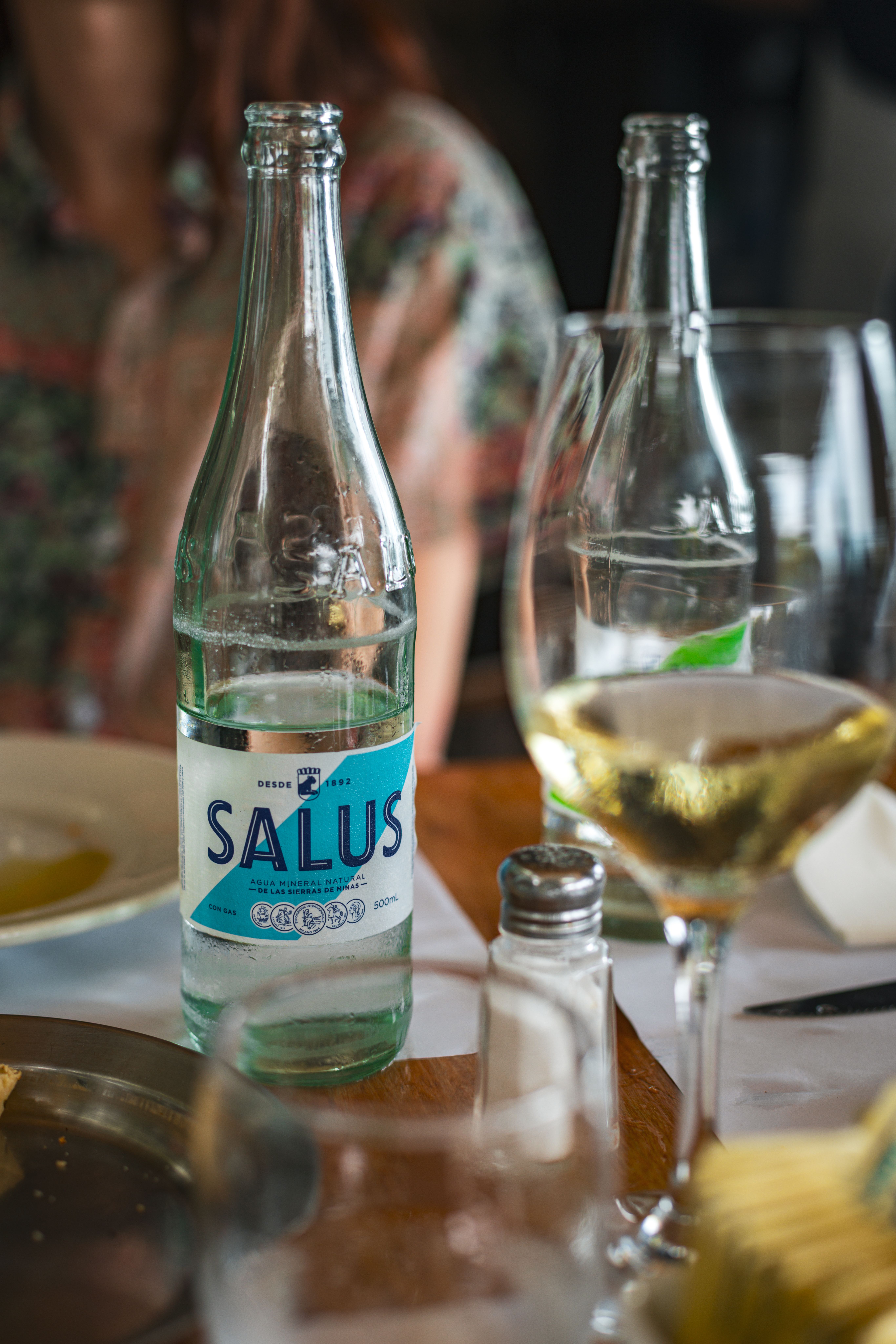 Close-up of Salus water and wine glasses on a restaurant table in Uruguay.