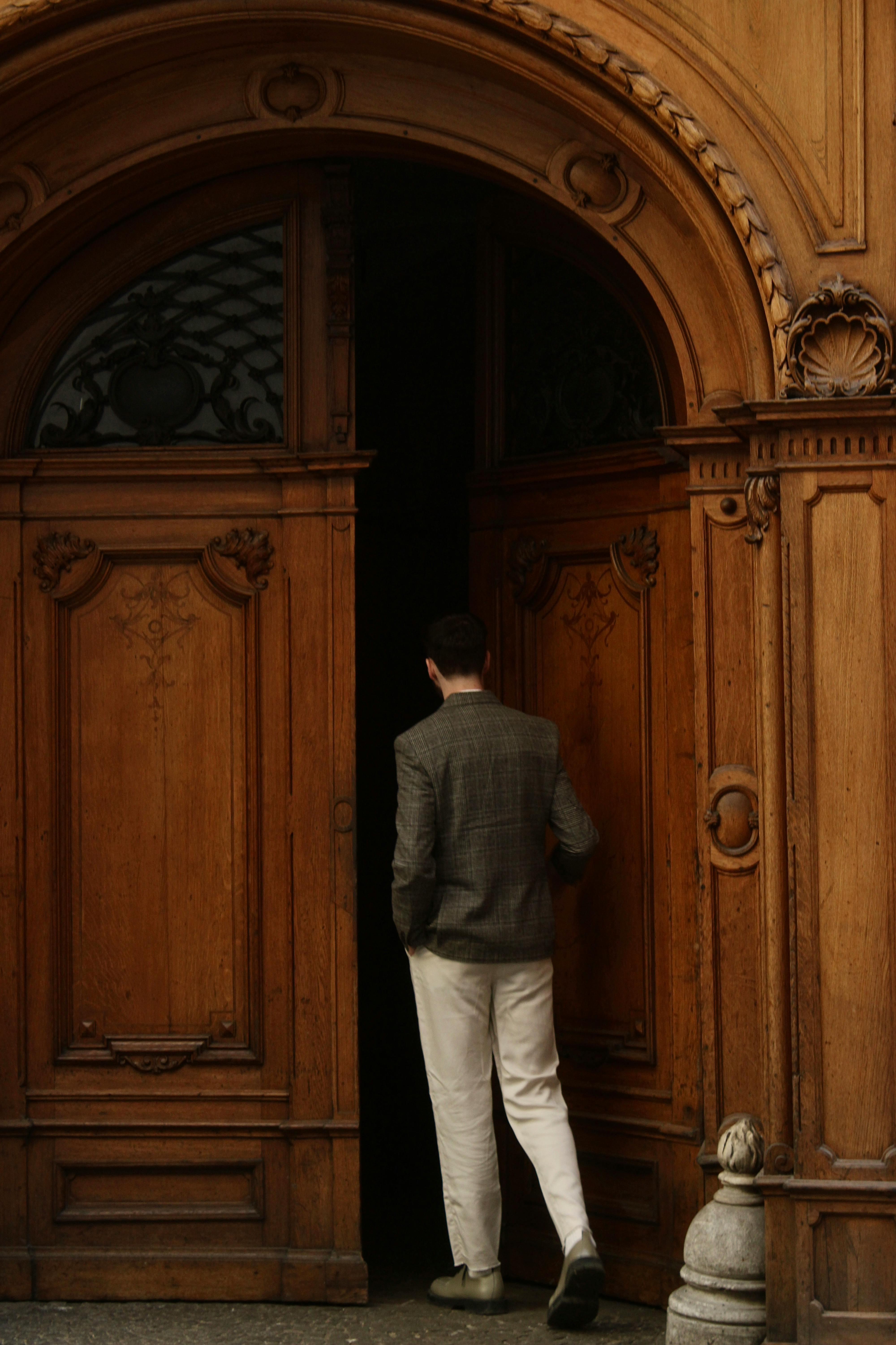 Free A man enters an ornate wooden doorway in Graz, Austria, highlighting classic architecture. Stock Photo